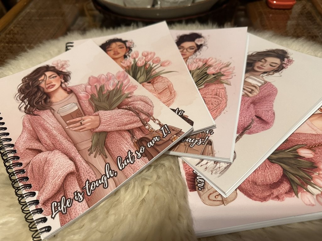 Collection of finished HEARTPRINTS metal-wired notebooks with coordinated pink illustrated covers
