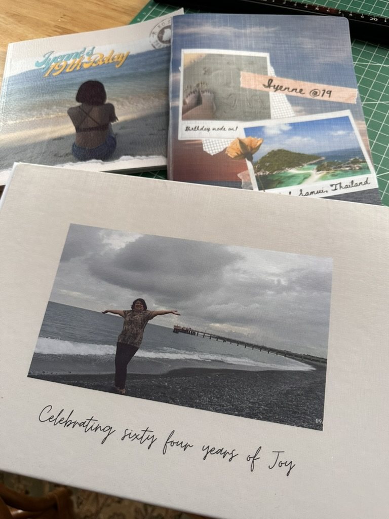 Three finished HEARTPRINTS personalized photobooks featuring birthday and travel memories