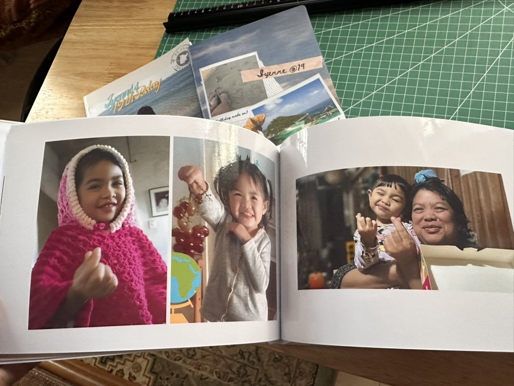 Open HEARTPRINTS photobook showing a clean family-photo layout across two pages